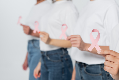 Image of 4 people hold a pink ribbon 