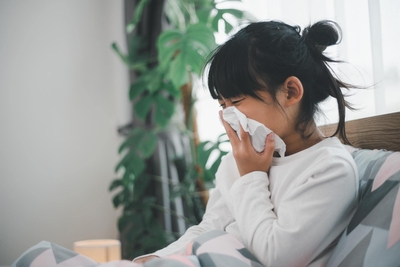 Image of a girl covering her nose with tissue