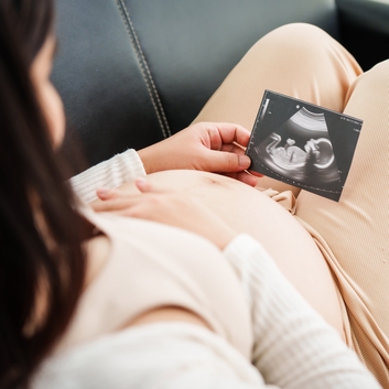 Image of an expectant mother with ultrasound of her baby